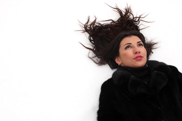 Une jeune femme marche dans un parc d'hiver en plein air