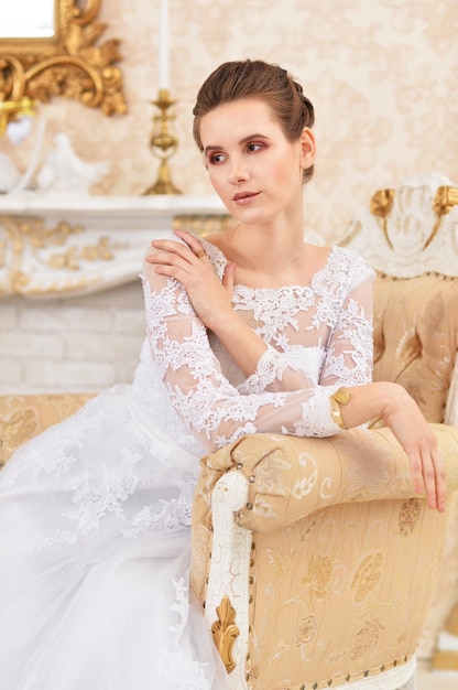 Jeune femme mariée assise sur une chaise dans la chambre hivernale