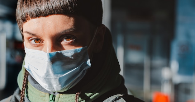 Jeune femme avec masque facial dans les rues. Protection contre le coronavirus