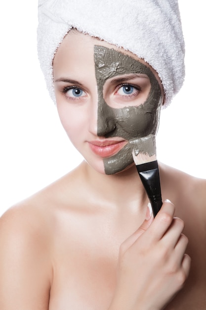 Jeune femme avec masque facial dans un spa de beauté.