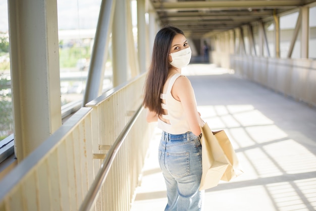 Jeune femme avec un masque facial est debout en plein air