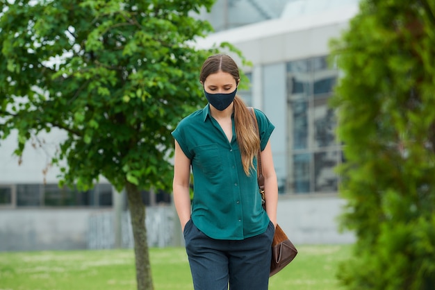 Jeune femme avec un masque noir dans la ville