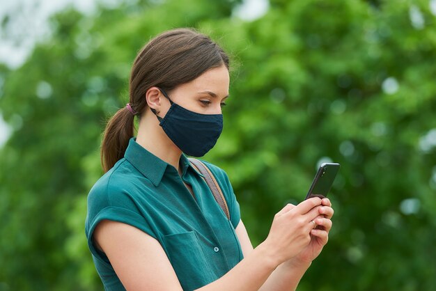 Jeune femme avec un masque noir dans la ville