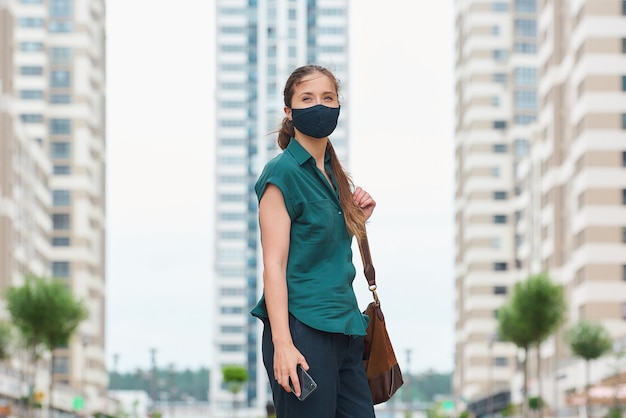 Jeune femme avec un masque noir dans la ville