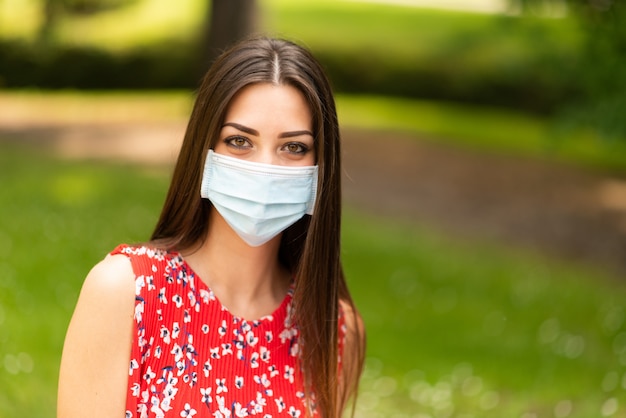 Jeune femme masquée dans un parc