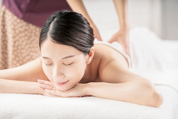 Jeune femme massée dans un salon de beauté avec une atmosphère lumineuse