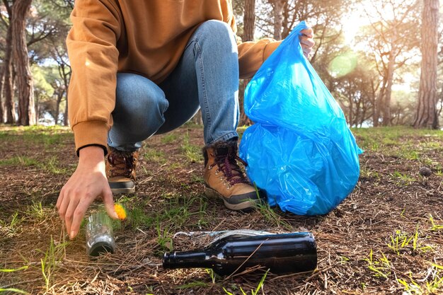 Jeune femme méconnaissable nettoyant la forêt. Militant environnemental et concept d'écologie.