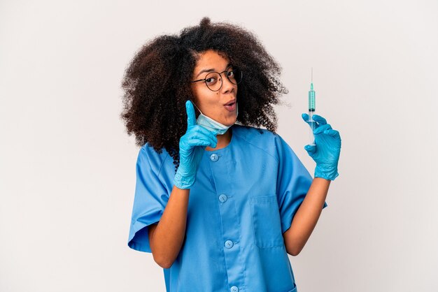 Jeune femme médecin afro-américaine bouclés tenant une seringue ayant une idée, le concept d'inspiration.