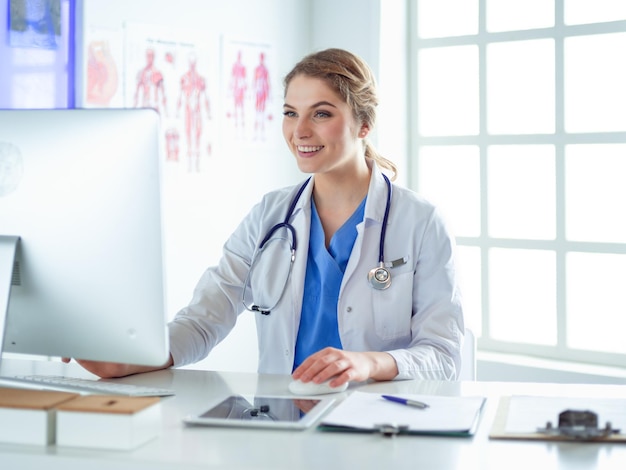 Jeune femme médecin assise à un bureau et travaillant sur l'ordinateur au bureau de l'hôpital Assurance soins de santé et concept d'aide Médecin prêt à examiner le patient