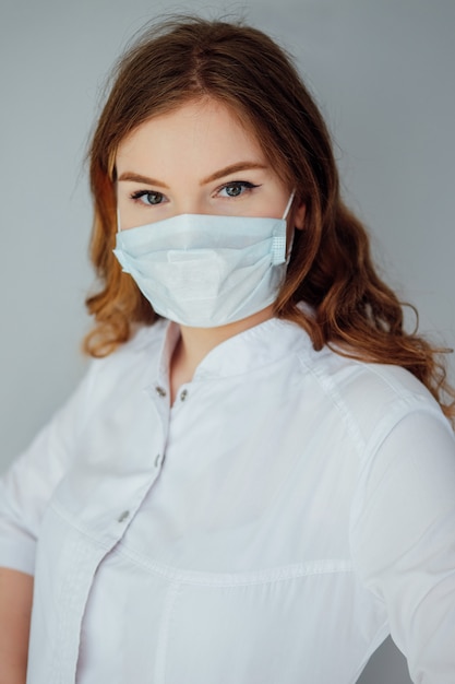 Jeune femme médecin dans une blouse blanche et un masque médical. La médecine