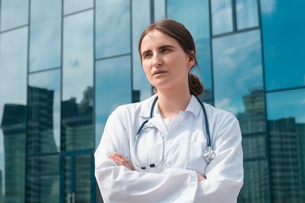 Jeune femme médecin debout à l'extérieur de l'hôpital se bouchent