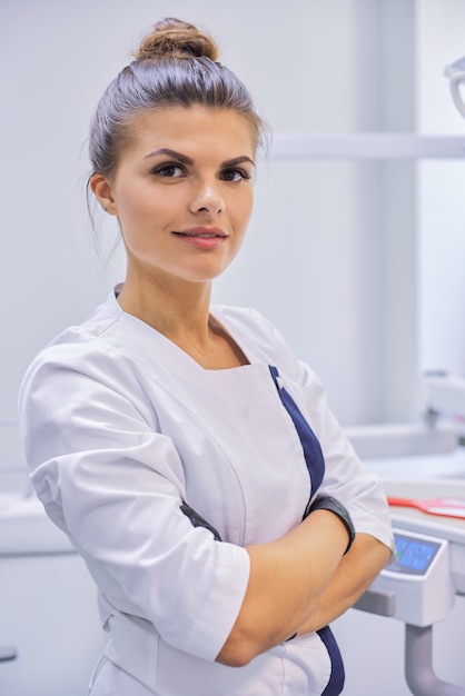 Jeune femme médecin dentiste confiant avec les bras croisés