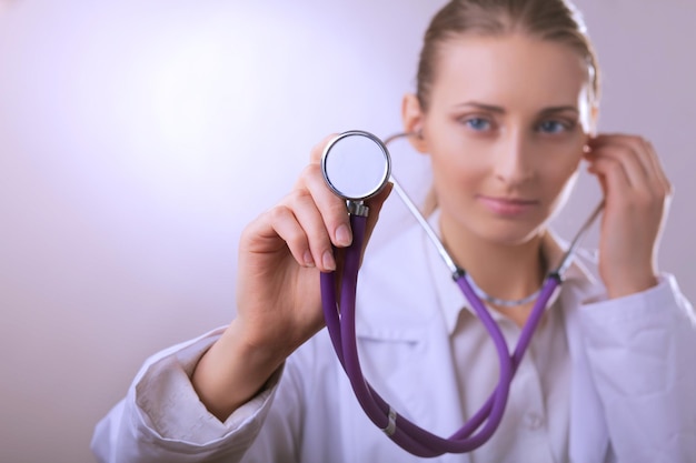 Une jeune femme médecin à l'écoute tenant un stéthoscope médical