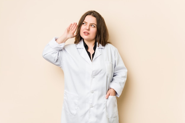 Jeune femme médecin essayant d'écouter un potin.