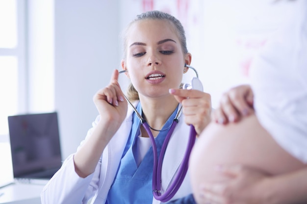 Jeune femme médecin examinant une femme enceinte à la clinique