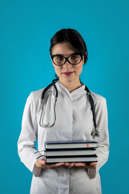 Une jeune femme médecin avec un grand sourire à pleines dents tient un livre