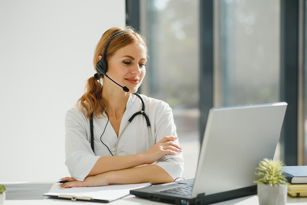 Jeune femme médecin parlant au patient en ligne du cabinet médical. Médecin consultant client sur ordinateur portable de chat vidéo à l'hôpital