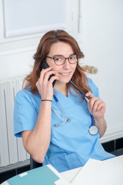 Jeune femme médecin parlant au téléphone