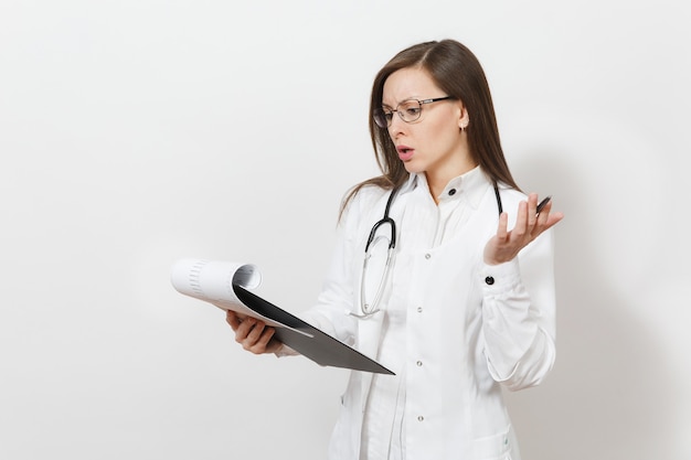 Jeune femme médecin pensive avec stéthoscope, lunettes isolées sur fond blanc. Femme médecin en blouse médicale tenant une carte de santé sur le dossier du bloc-notes. Concept de médecine du personnel de santé.