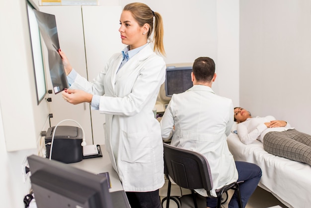 Jeune femme médecin regardant l&#39;image radiographique du patient à l&#39;hôpital