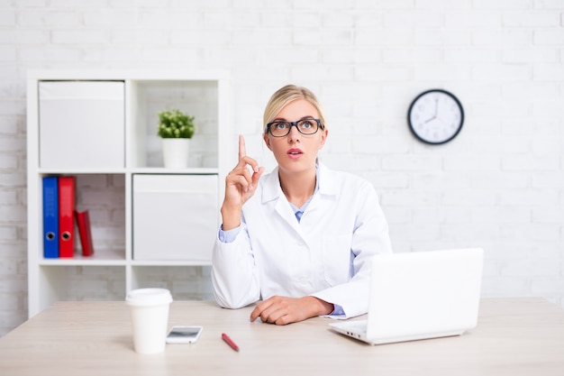 Jeune femme médecin ou scientifique montrant une idée au bureau