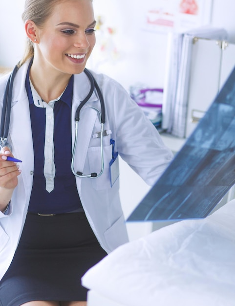 Jeune femme médecin séduisante regardant l'image radiographique