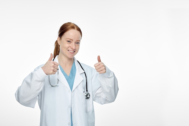 Jeune femme médecin souriante faisant les pouces vers le haut de signe. Photo de haute qualité