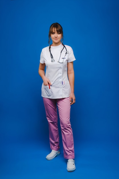 Jeune femme médecin avec stéthoscope isolé sur fond bleu.