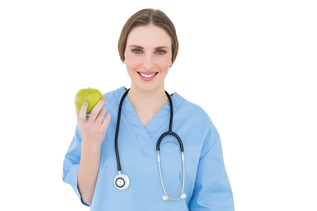 Jeune femme médecin tenant une pomme verte