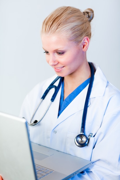 Jeune femme médecin travaillant sur un ordinateur portable