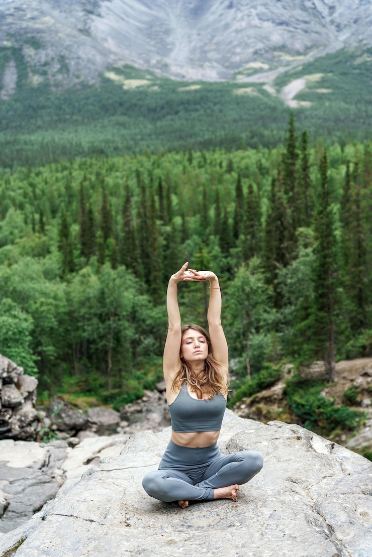 Photo une jeune femme médite, s'entraîne au yoga dans la nature, dans les montagnes, s'assoit dans une pose d'asana dans la nature.