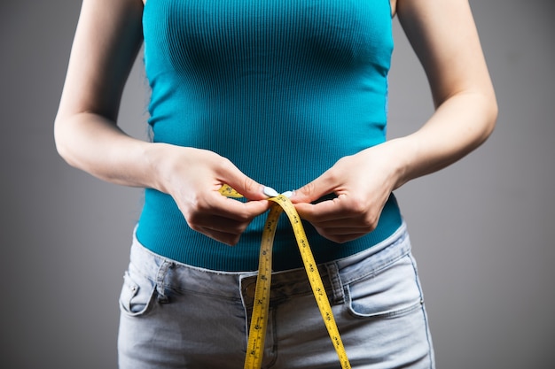 Jeune femme mesurant la circonférence abdominale