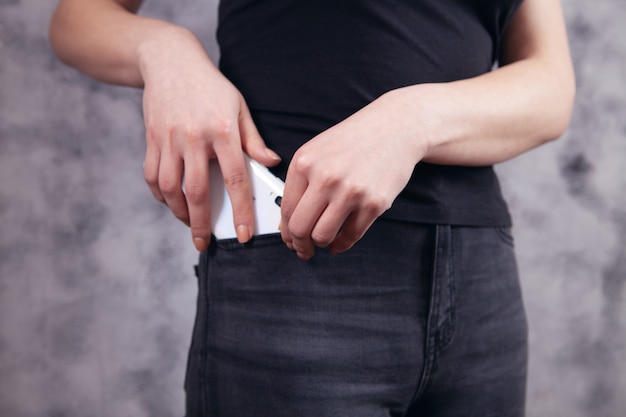 La jeune femme met le téléphone dans sa poche