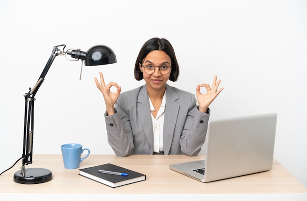 Jeune femme métisse d'affaires travaillant au bureau dans une pose zen