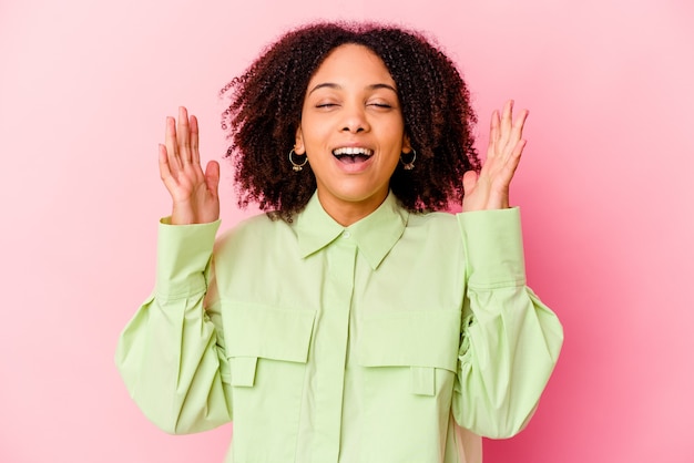 Jeune femme métisse afro-américaine isolée éclate de rire en gardant la main sur la poitrine.