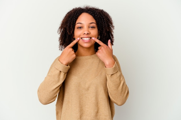 Jeune femme métisse afro-américaine sourit isolé, pointant du doigt la bouche.