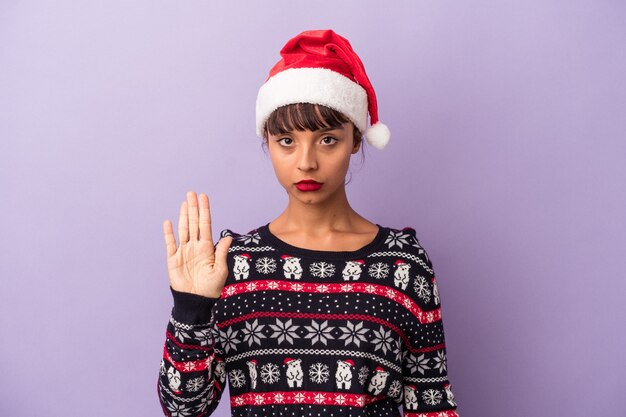 Jeune femme métisse célébrant Noël isolé sur fond violet debout avec la main tendue montrant un panneau d'arrêt, vous empêchant.