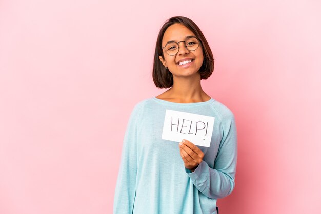 Jeune femme métisse hispanique tenant une affiche d'aide heureuse, souriante et joyeuse.