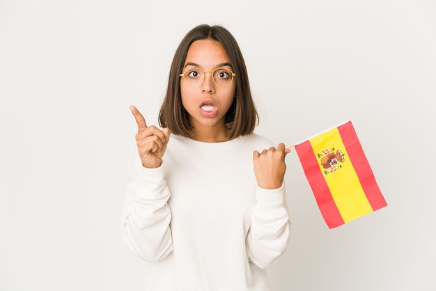 Jeune femme métisse hispanique tenant un drapeau espagnol ayant une idée, un concept d'inspiration.