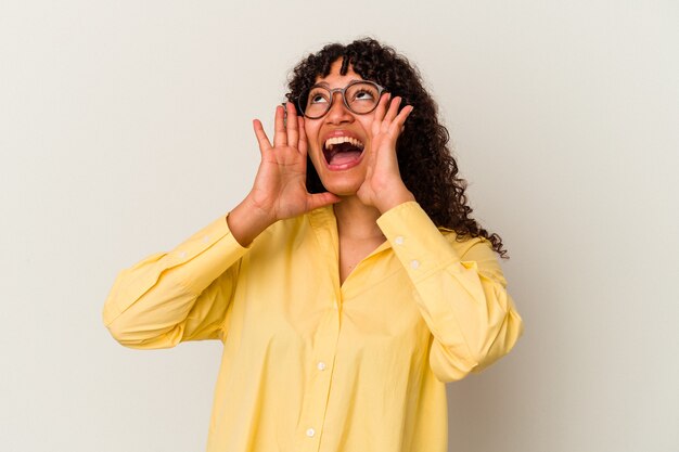 Jeune femme métisse isolée sur fond blanc criant excité à l'avant.