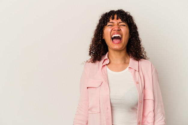 Jeune femme métisse isolée sur fond blanc criant très en colère, concept de rage, frustré.