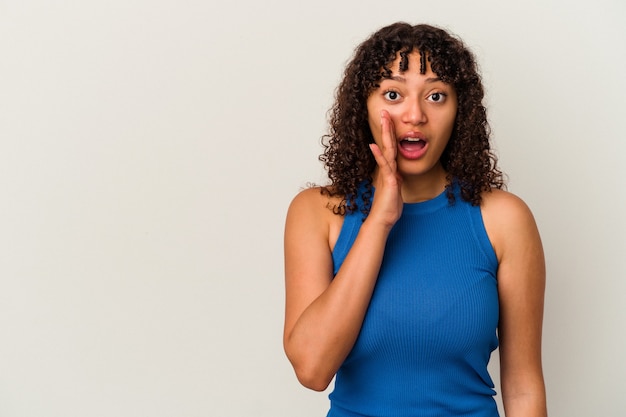 Jeune femme métisse isolée sur fond blanc crie fort, garde les yeux ouverts et les mains tendues.