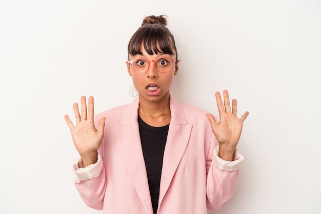 Jeune femme métisse isolée sur fond blanc recevant une agréable surprise, excitée et levant les mains.