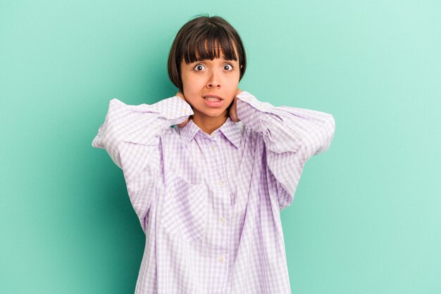 Jeune femme métisse isolée sur fond bleu pointant avec les index vers un espace de copie, exprimant l'excitation et le désir.