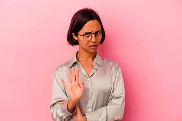 Jeune femme métisse isolée sur fond rose choquée en raison d'un danger imminent