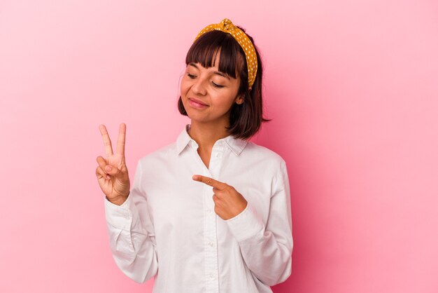 Jeune femme métisse isolée sur fond rose prêtant serment, mettant la main sur la poitrine.