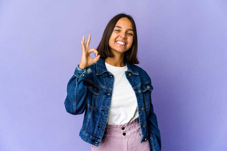 Photo jeune femme métisse joyeuse et confiante montrant un geste correct.