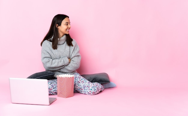 Jeune femme métisse de manger du pop-corn en regardant un film