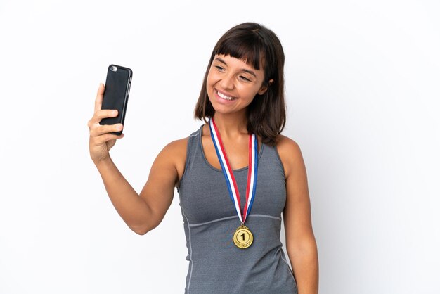 Jeune femme métisse avec des médailles isolées sur fond blanc faisant un selfie