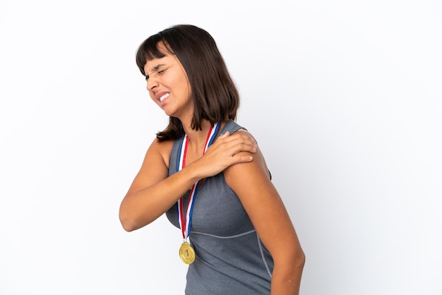 Jeune femme métisse avec des médailles isolées sur fond blanc souffrant de douleurs à l'épaule pour avoir fait un effort